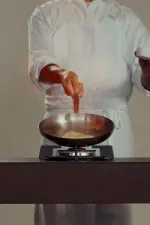 Chariot à flamber en chêne de Bourgogne teinté avec un plateau Dekton, un feu gaz intégré, une étagère inférieure et une poignée en acier inoxydable.