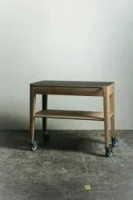 Chariot de service en chêne de Bourgogne avec un plateau supérieur, une étagère inférieure et une poignée en acier inoxydable, monté sur quatre roulettes.