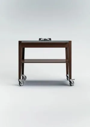 Chariot à flamber en chêne de Bourgogne teinté avec un plateau Dekton, un feu gaz intégré, une étagère inférieure et une poignée en acier inoxydable, monté sur quatre roulettes.